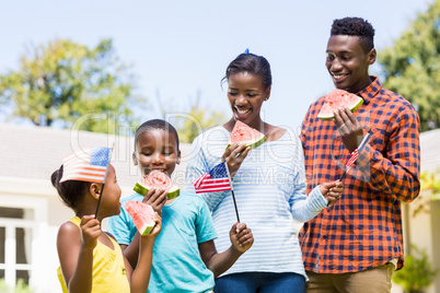Happy family eating watermelon and showing usa flag
