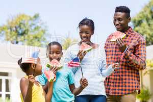 Happy family eating watermelon and showing usa flag