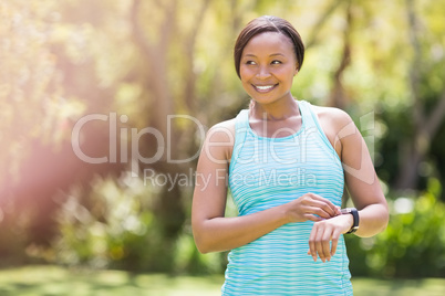 Happy woman posing and touching her watch