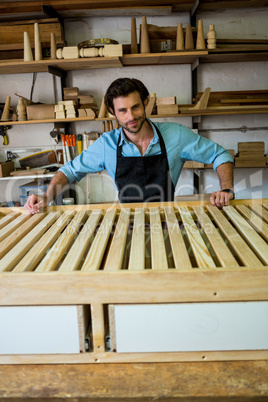 Carpenter is posing with his craft