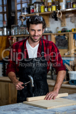 Carpenter smiling and working on his craft