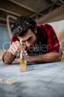 Carpenter painting a piece of wood