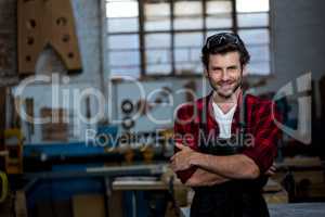 Carpenter smiling and crossing arms