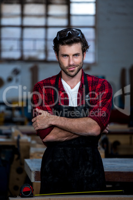 Carpenter smiling and crossing arms