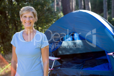 Senior woman standing in front of a tent