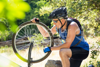 Senior man is touching his bike