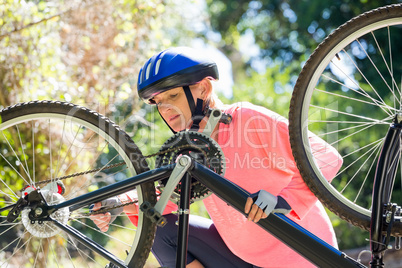 Senior woman is reparing her bike