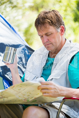 senior man reading beside his tent