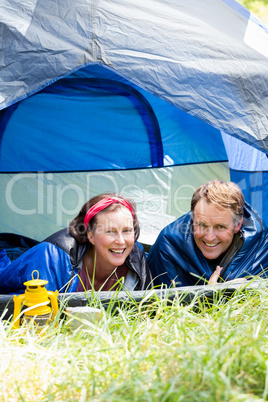 senior couple smiling inside their tent
