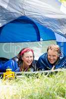 senior couple smiling inside their tent