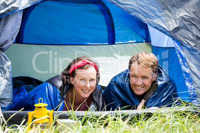 senior couple smiling inside their tent