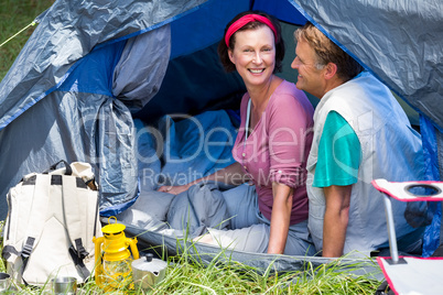 senior couple smiling inside their tent