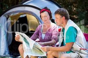 senior couple looking the map beside the tent