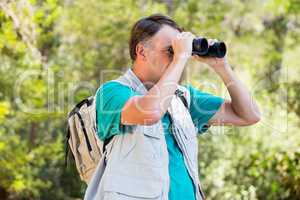 senior man is looking in his binoculars