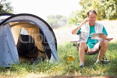 senior man is reading and talking on the phone