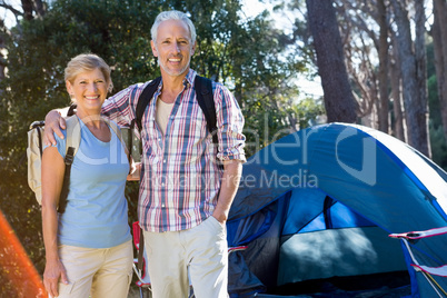 senior couple standing beside their tent