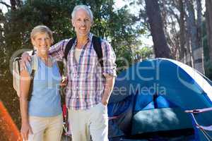 senior couple standing beside their tent