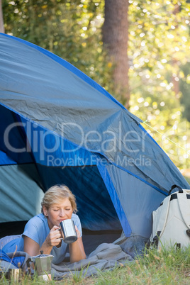 Mature woman laying and drinking on a mug