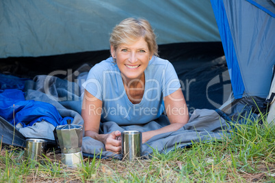 Mature woman laying smiling and holding a mug