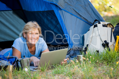 Mature woman smiling and using computer