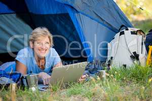 Mature woman smiling and using computer