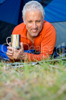 Mature man smiling and holding a mug