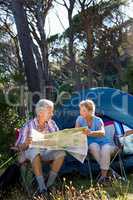 Mature couple looking map on camp site