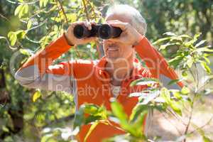 Mature man looking on binoculars