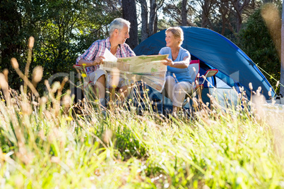 Mature couple smiling and reading a map