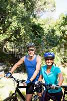 Mature couple with sunglasses posing with their bikes
