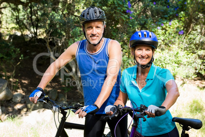 Mature couple posing with their bike