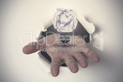 Composite image of hand ripping through paper