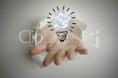 Composite image of hand bursting through paper