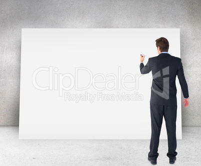 Composite image of businessman standing back to camera writing w