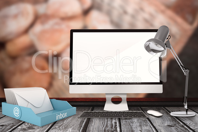 Composite image of a computer over a desk