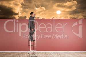 Composite image of happy businessman standing on ladder