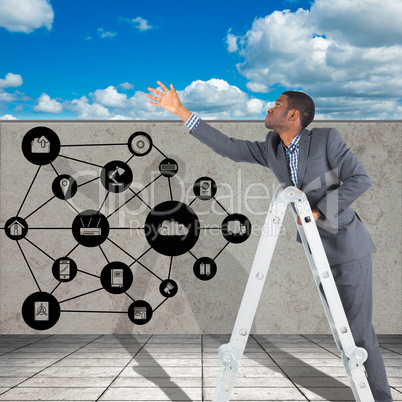 Composite image of businessman looking on a ladder