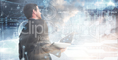 Composite image of businessman looking up holding laptop