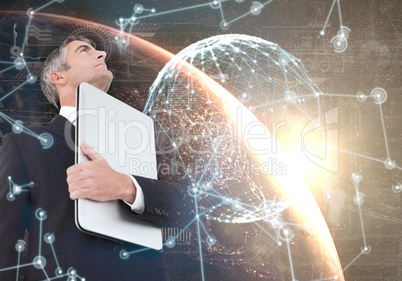 Composite image of businessman in suit holding his laptop proudl