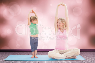 Composite image of pregnant smiling mother and daughter doing yo