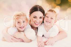 Composite image of happy mother and her children lying on a bed