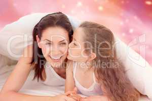 Composite image of mother and her daughter having fun on bed