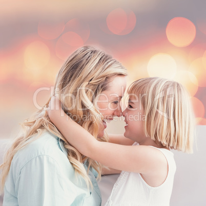 Composite image of mother and daughter rubbing noses on sofa