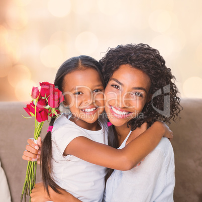 Portrait of a pretty mother sitting  with her daughter holding roses