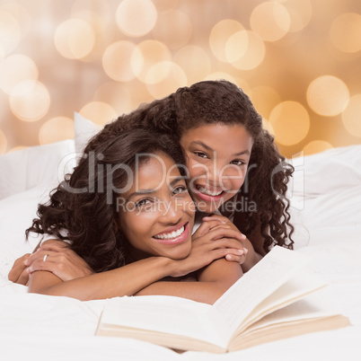 Composite image of mother and daughter reading book together on bed