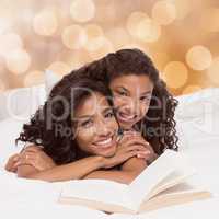 Composite image of mother and daughter reading book together on bed