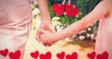 Composite image of close up of mother and daughter holding hands