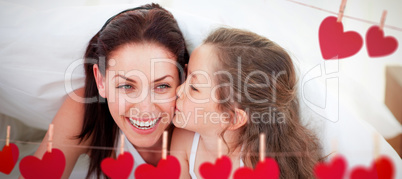 Composite image of mother and her daughter having fun on bed