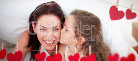 Composite image of mother and her daughter having fun on bed