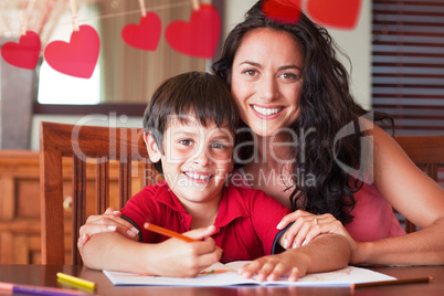 Composite image of happy mother helping his son for homework